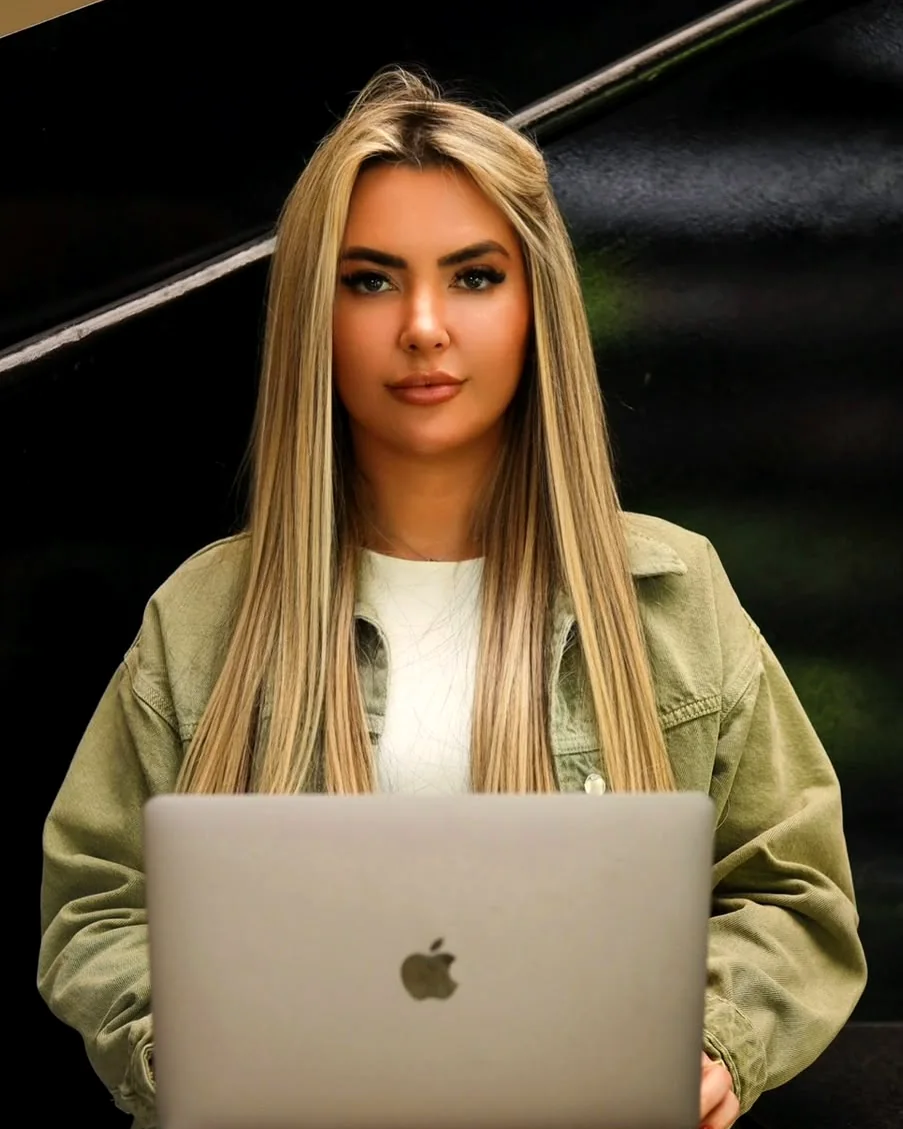Graziele Dalpra sentada com o notebook no colo